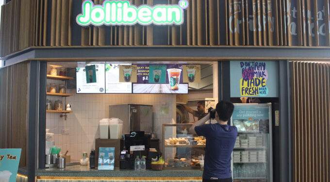 A person takes a picture of a Jollibean outlet in Singapore. Photo from Facebook/JollibeanSingapore